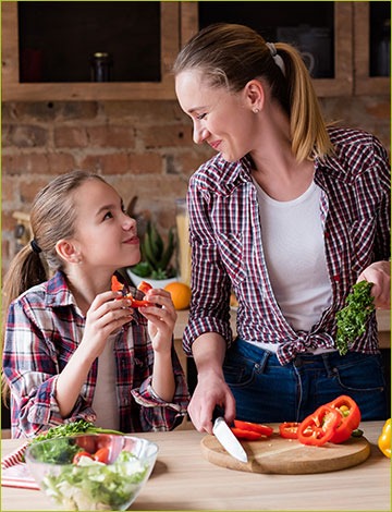 Woman and daughter prepare vegetarian meal