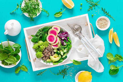 Vegan lunch bowl with quinoa, cucumber, green peas, radish, romanesco and red cabbage, avocado, spinach and arugula salad, healthy eating, vegetarian food concept, veggie detox and antioxidant diet
